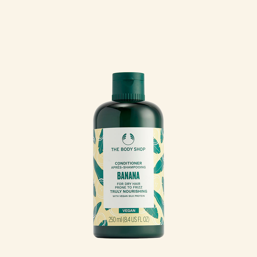 Acondicionador de plátano vegano con puré de plátano orgánico, proteína de seda vegana y fragancia afrutada, diseñado para suavizar, reducir el encrespamiento y nutrir el cabello seco desde la raíz hasta las puntas, en una botella hecha con plástico 100% reciclado y certificado por The Vegan Society