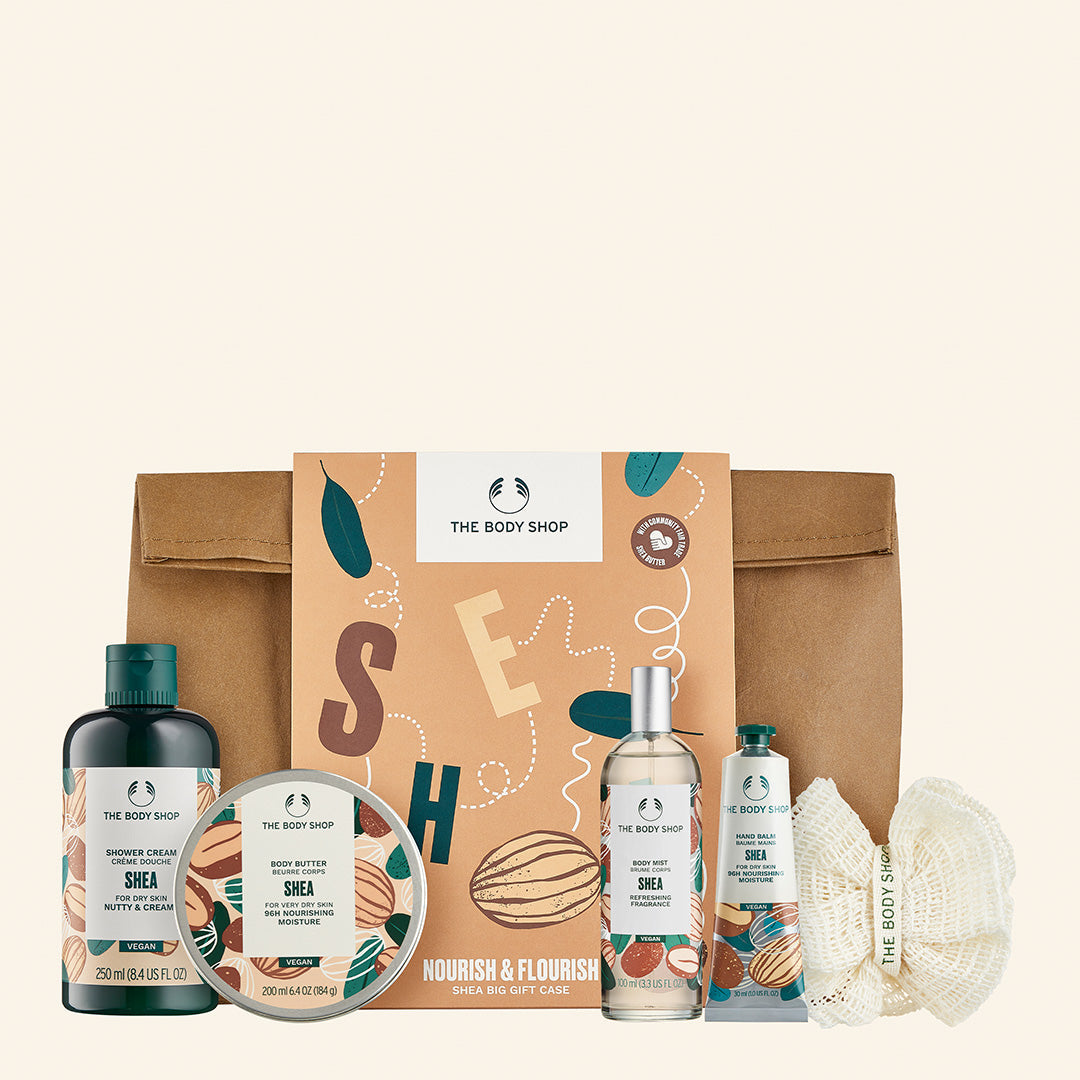 Set de regalo mediano de manteca de karité con crema de ducha, manteca corporal, bálsamo de manos, bruma corporal y esponja de baño, elaborado con ingredientes de comercio justo y envases reciclados, que promueve el cuidado de la piel y apoya comunidades en Ghana e India