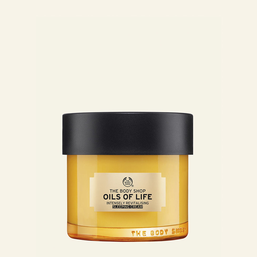 Imagen de la crema de noche intensamente revitalizante Oils of Life™ de The Body Shop, con textura cremosa y enriquecida con aceites de semillas de comino negro, camelia y rosa mosqueta, diseñada para hidratar en profundidad y reparar mientras duermes, ayudando a despertar con una piel más suave, elástica y revitalizada, especialmente ideal para piel deshidratada y cansada, con ingredientes de origen natural como aceite de oliva orgánico de comercio justo de Italia