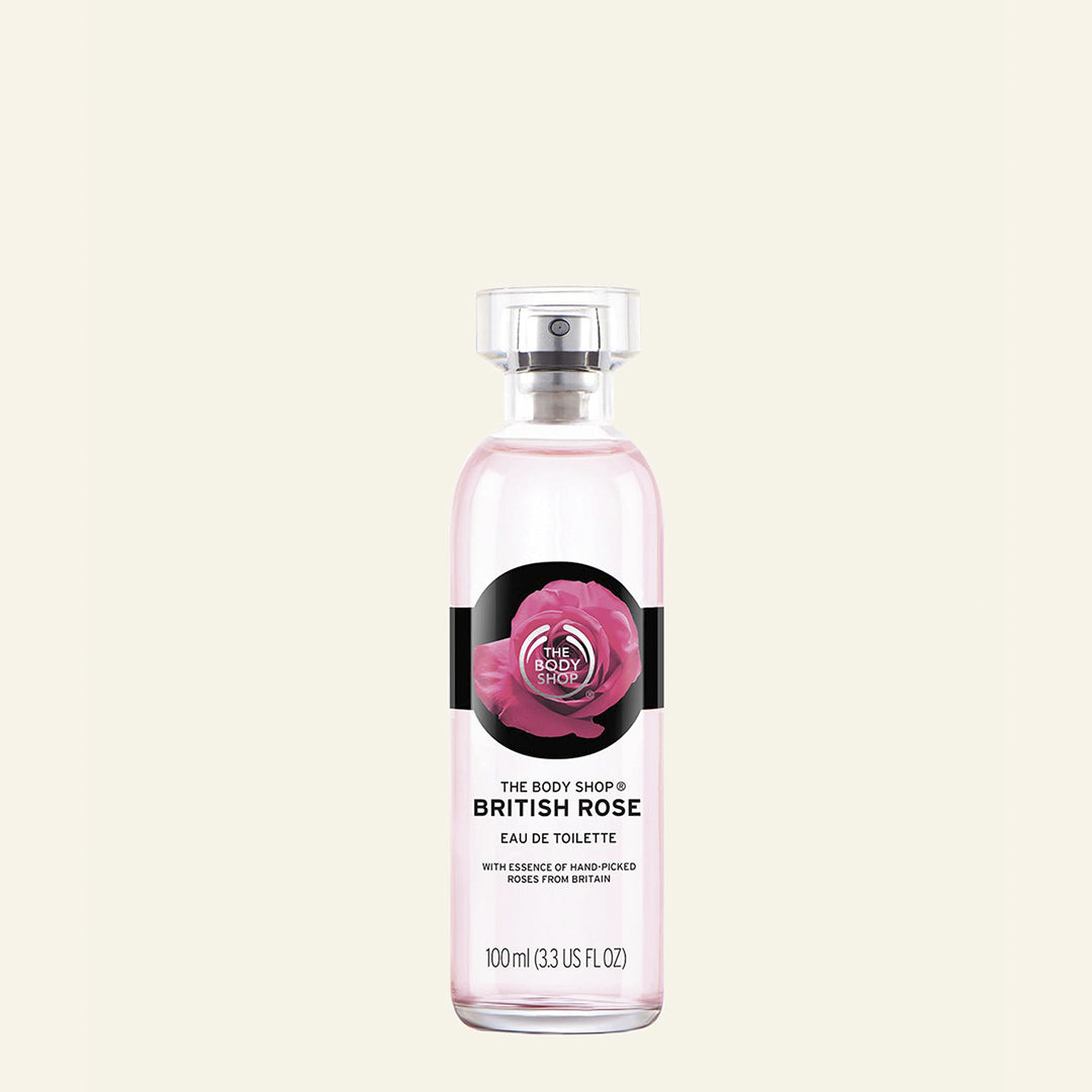 Imagen de la botella de Eau de Toilette British Rose, una fragancia floral con aroma a rosas frescas, en un frasco reciclable que refleja un compromiso ecológico, acompañado de un ramo de rosas y elementos que evocan la campiña inglesa en primavera