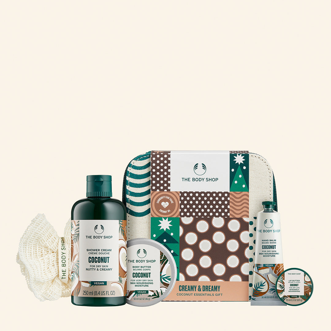 Conjunto de regalo Creamy & Dreamy Coconu Essentials que incluye gel de ducha, body butter, bálsamo de manos, manteca labial y una borla de baño, todos enriquecidos con ingredientes naturales de coco y manteca de karité, ideal para piel seca y para cuidar el planeta