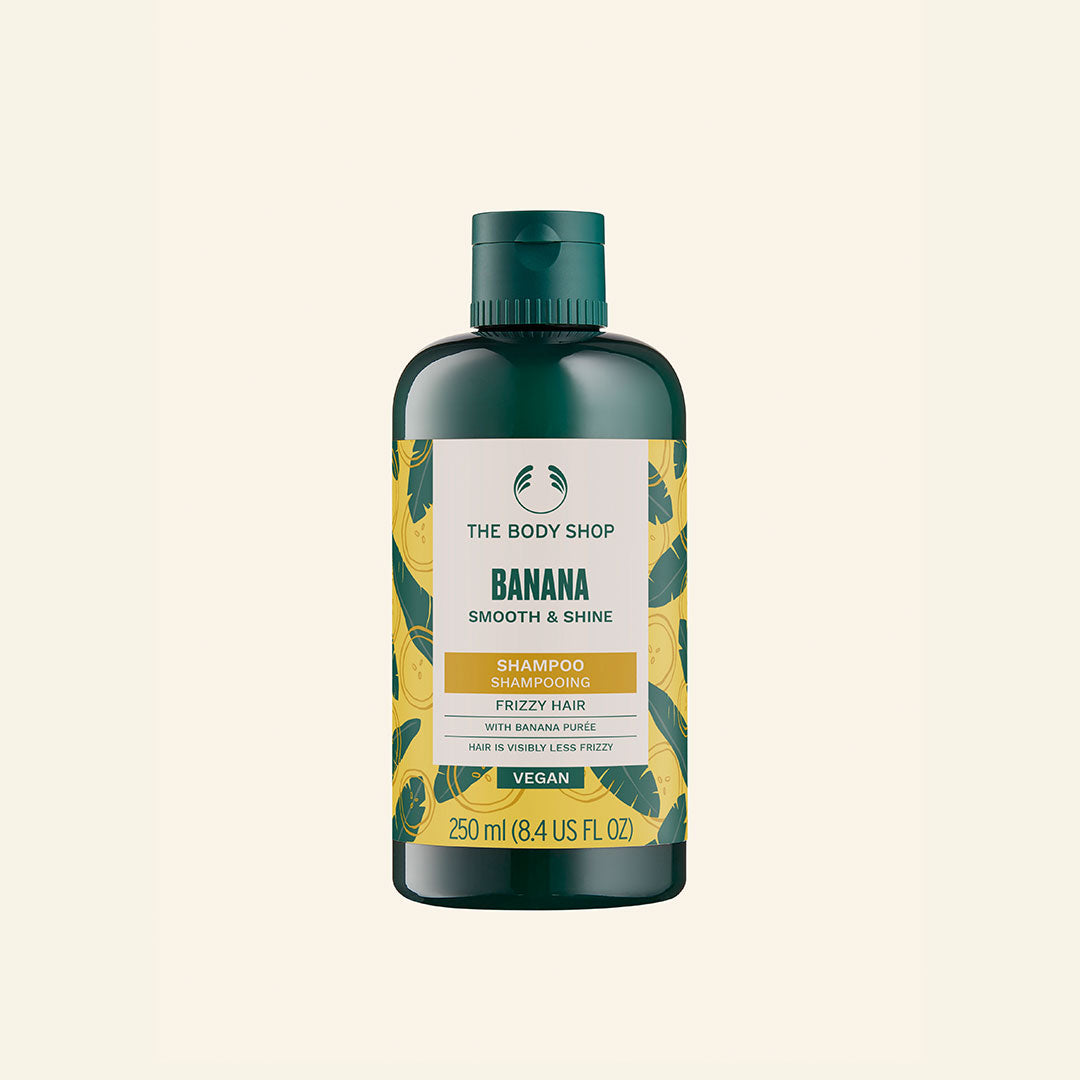 Botella de Shampoo de Plátano de 250 ml con imagen que muestra el envase y su descripción, destacando su fórmula nutritiva con puré de plátano orgánico, aroma tropical, y beneficios para cabello normal a seco, libre de siliconas y elaborado con comercio comunitario de Ecuador
