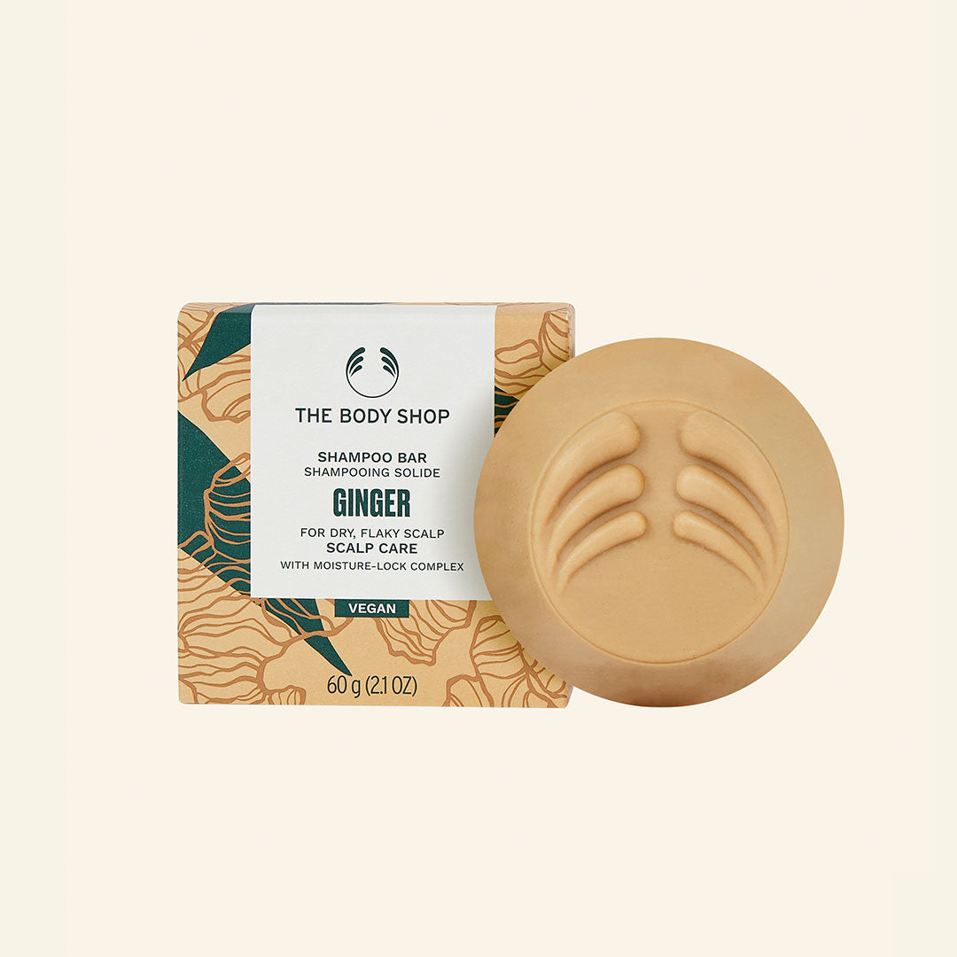 Imagen de una barra de shampoo de jengibre con base ergonómica, diseñada para cabello seco y con caspa, que muestra una textura cremosa y enriquecida con ingredientes naturales como aceite esencial de jengibre, corteza de abedul y extracto de corteza de sauce blanco, perfecta para una limpieza suave, hidratación y alivio del cuero cabelludo seco