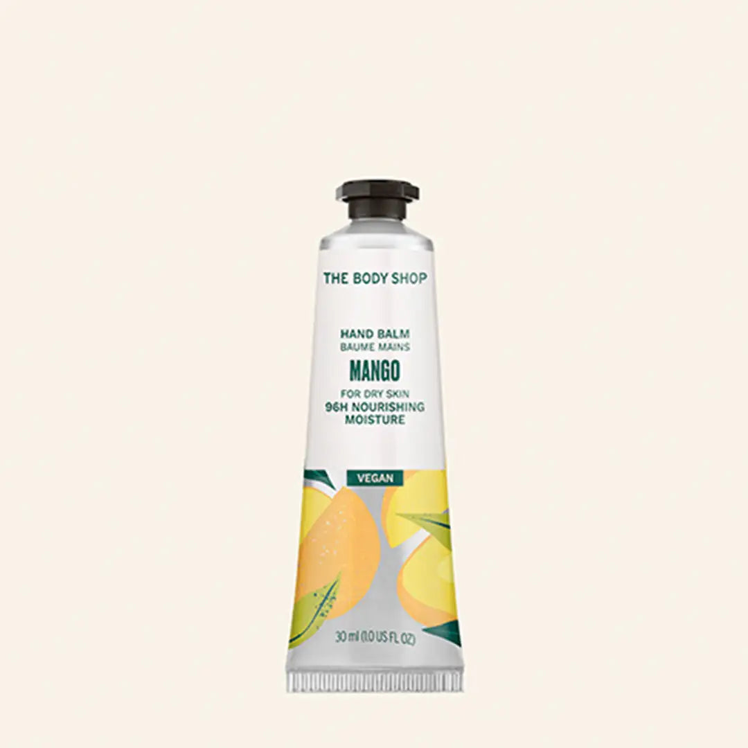 Crema de manos de mango en envase blanco sobre fondo rosa claro